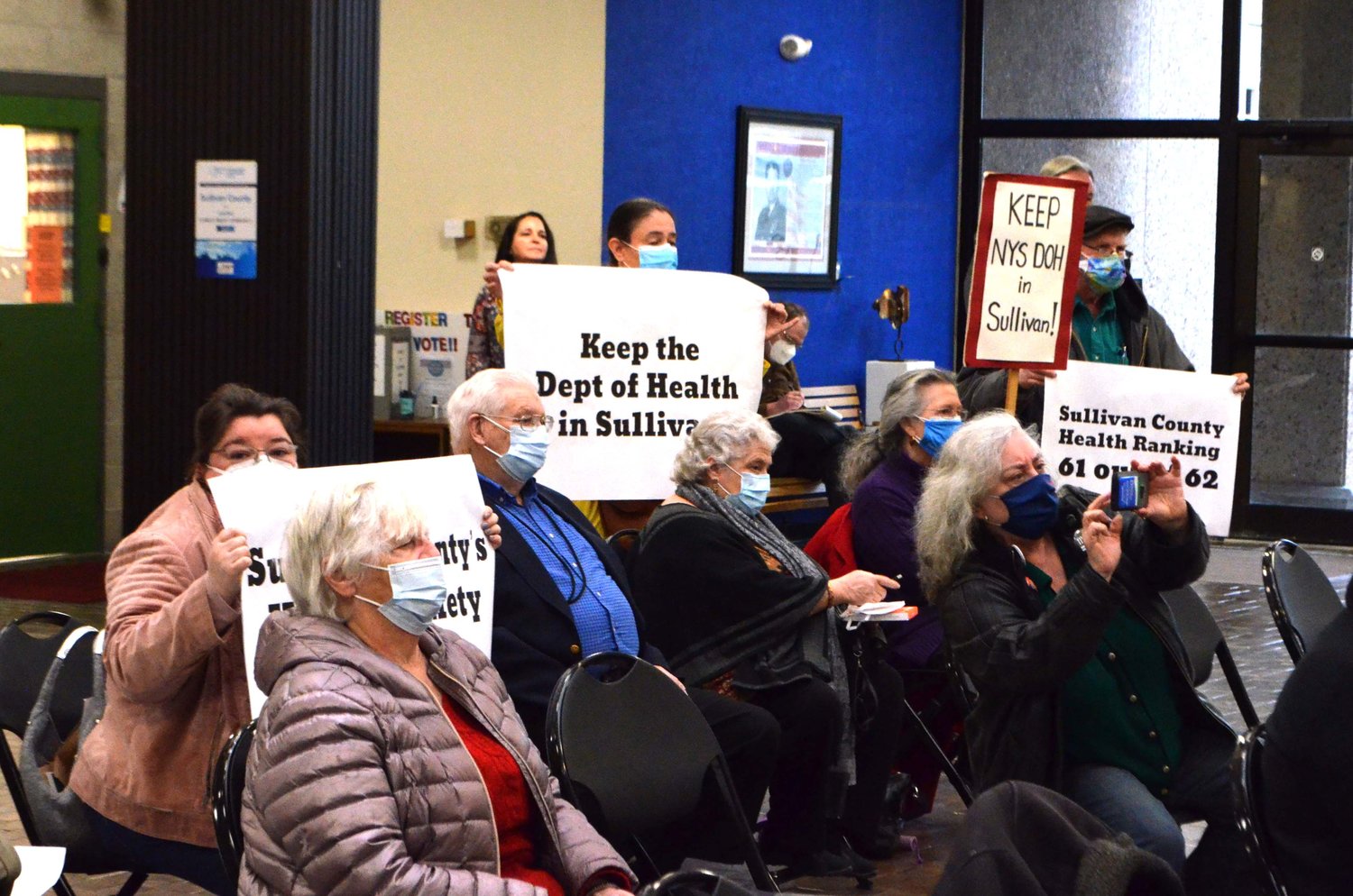 Signs were waved from the audience at the February 8 press conference, held to advocate for the DoH district office to remain in Monticello.